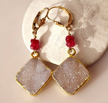 Load image into Gallery viewer, A pair of gold foiled edged square druzy stones, ruby faceted beads, and 14 karat gold-filled leverback closures.