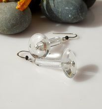 Load image into Gallery viewer, Clear acrylic disc and crystal Quartz tubes with silver fishhook wires and small black Onyx beads, displayed on a white surface with gray stones in the background.