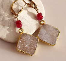 Load image into Gallery viewer, A pair of gold foiled edged square druzy stones, ruby faceted beads, and 14 karat gold-filled leverback closures.
