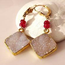Load image into Gallery viewer, A pair of gold foiled edged square druzy stones, ruby faceted beads, and 14 karat gold-filled leverback closures.
