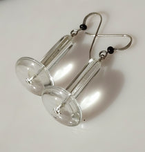 Load image into Gallery viewer, Clear acrylic disc and crystal Quartz tubes with silver fishhook wires and small black Onyx beads, displayed on a white surface with gray stones in the background.
