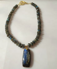 Load image into Gallery viewer, A beaded necklace made of blue and green labradorite beads with a large rectangular labradorite pendant, accented with 14 karqat gold-filled toggle clasp.
